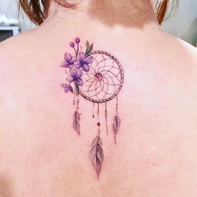 Tatouage attrape rêve avec trois petites fleures violettes sur le dos